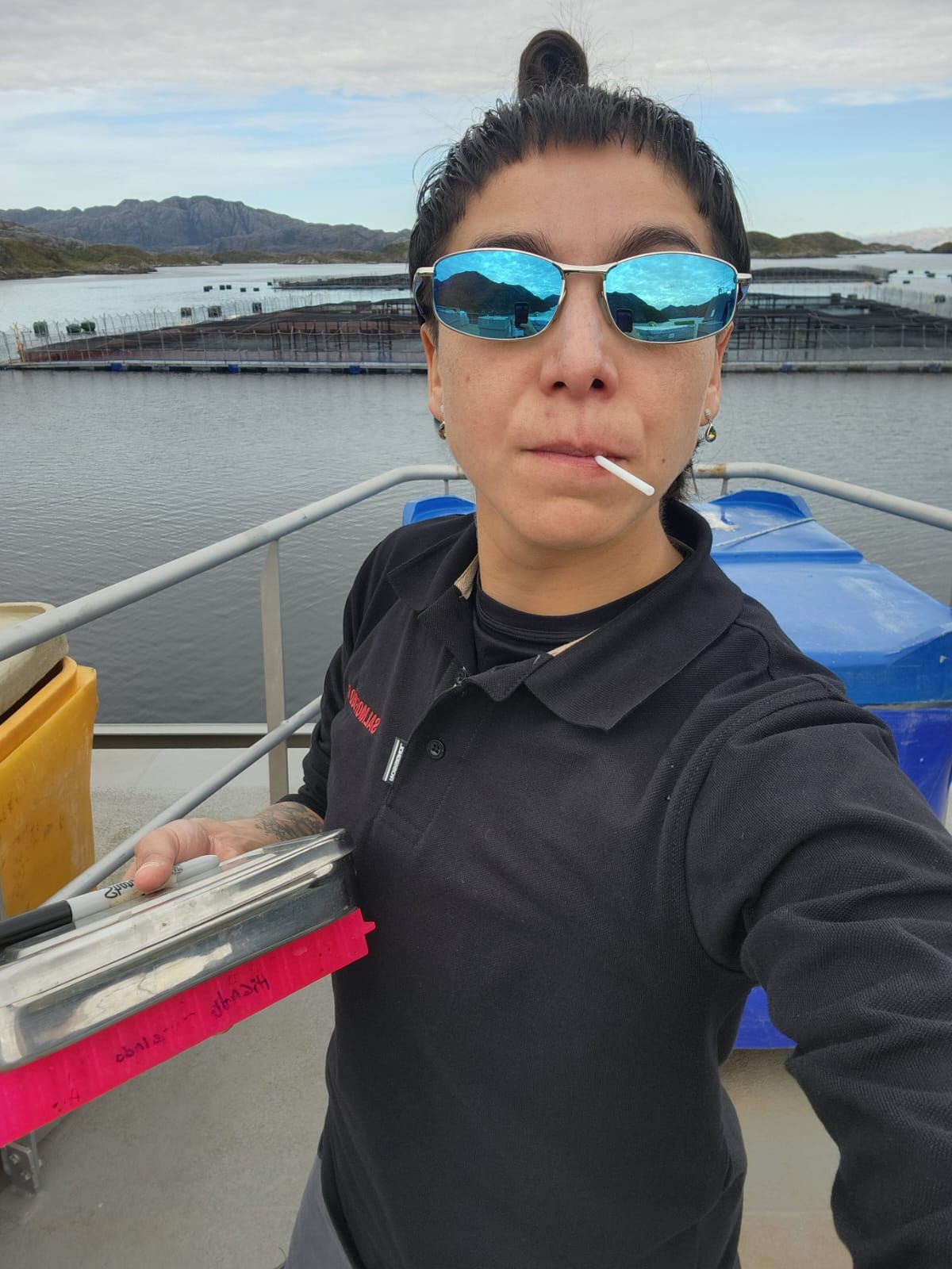 Profesional de WICA en terreno frente a jaulas de cultivo de salmón