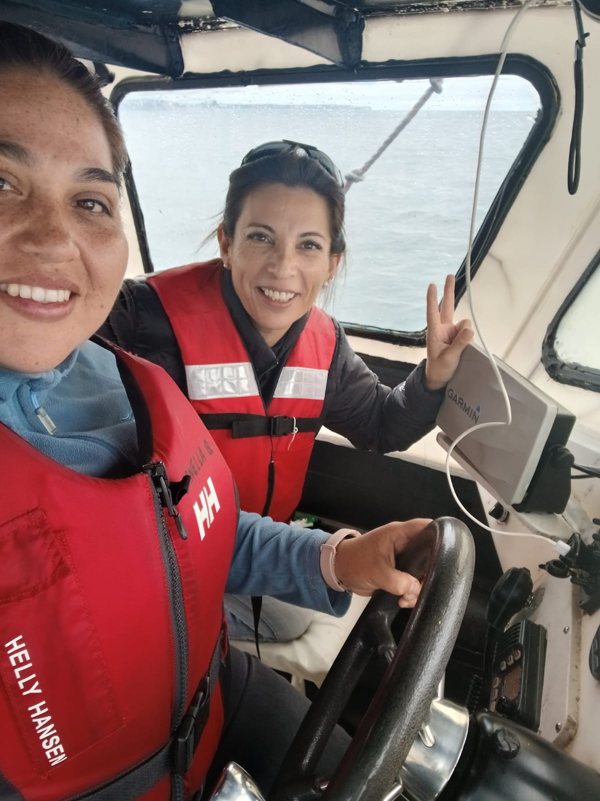 Dos profesionales de WICA sonriendo dentro de la cabina de una embarcación